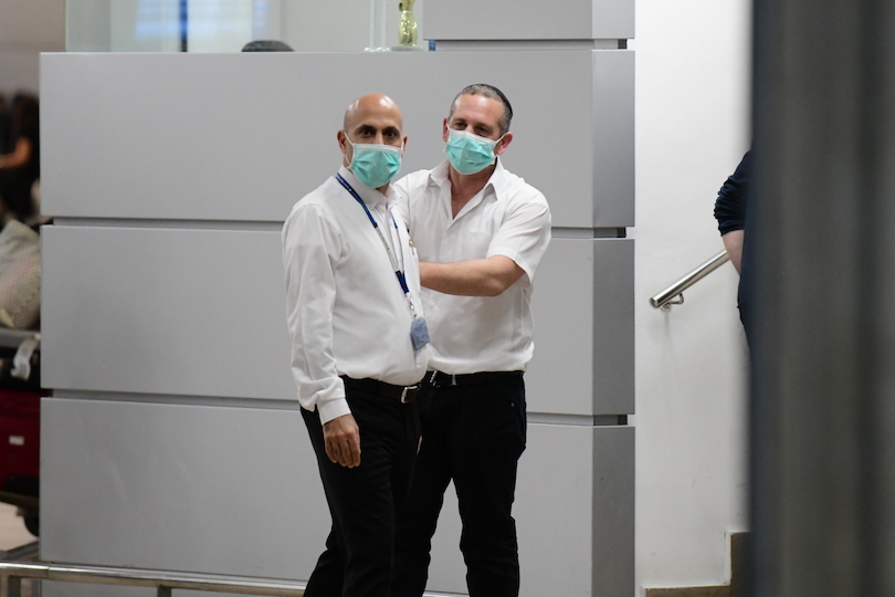 אנשים לובשים מסכות פנים באולם ההגעה של נמל התעופה בן גוריון (צילום: תומר נויברג, פלאש 90)