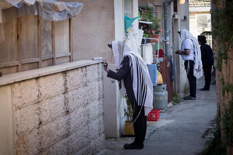 מתפללים בכניסה לביתם בירושלים, שלשום (צילום: יונתן זינדל, פלאש 90)