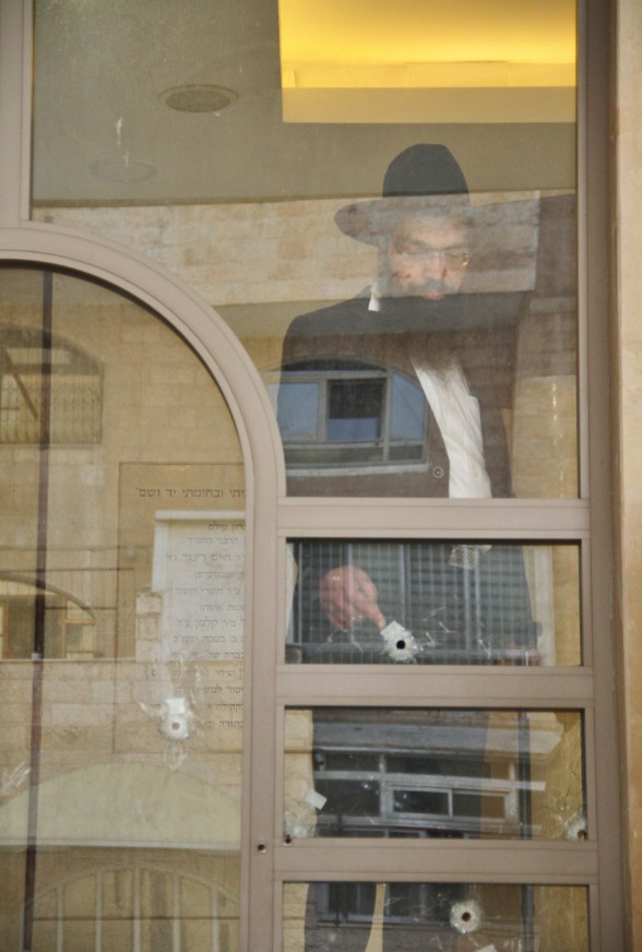 מצביע על החורים שנשארו על החלון בבית הכנסת