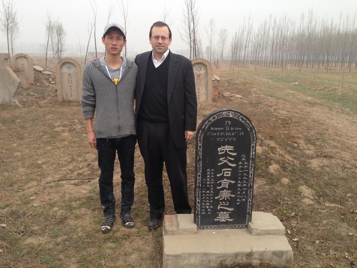מיכאל פרוינד ויעקב וואנג, עומדים לצד קבר סבו של וואנג, בפאתי העיר