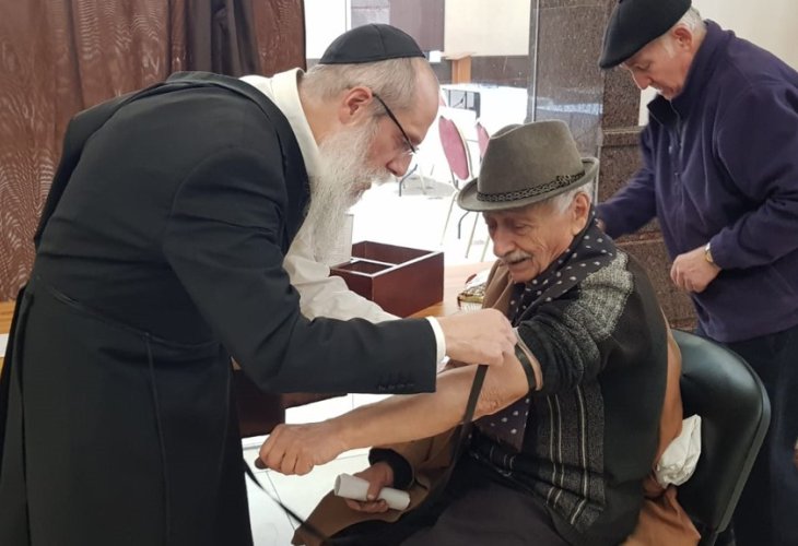 Rabbi Wilhelm putting on tefillin in the local Jewish community (photo courtesy)