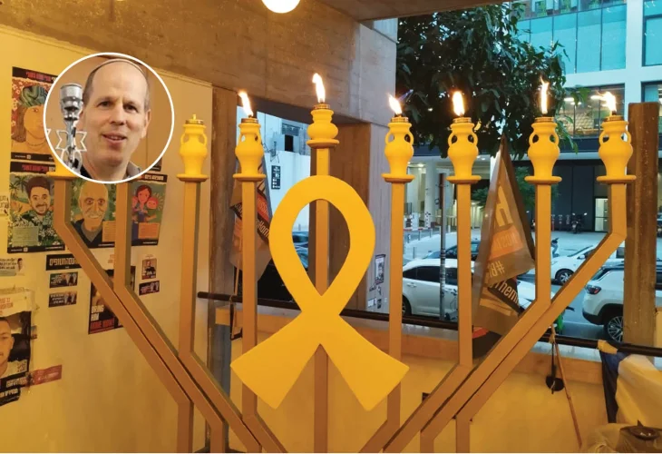 Avivi Shifris against the backdrop of one of his menorah designs
