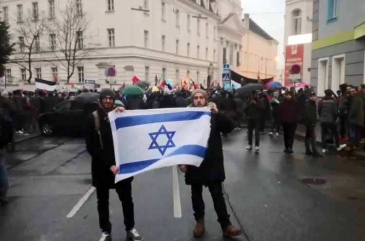 שני הסטודנטים עם דגל ישראל בסמוך להפגנה הפרו-מוסלמית