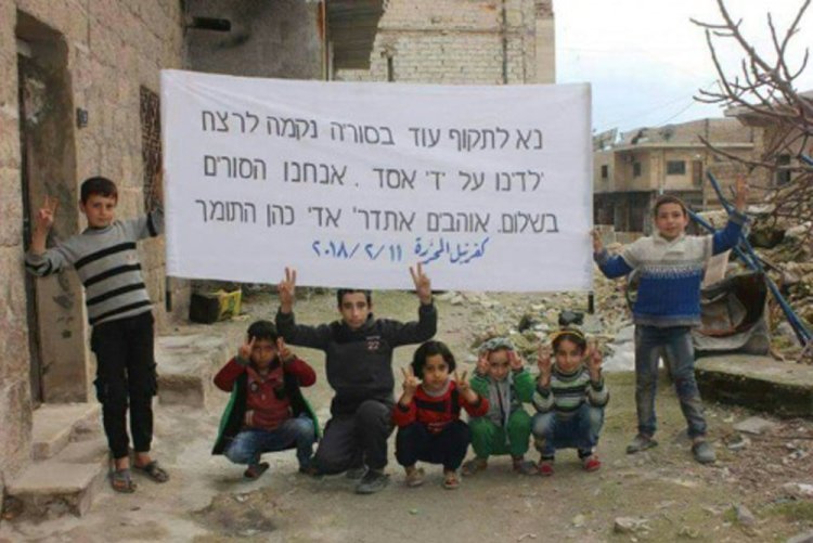 ילדים סורים מניפים שלט: "נא לתקוף עוד בסוריה" (צילום: תקשורת ערבית)