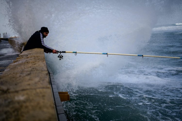 דייג ביפו, בעיצומו של מזג האוויר החריג (צילום: תומר ניוברג, פלאש 90)