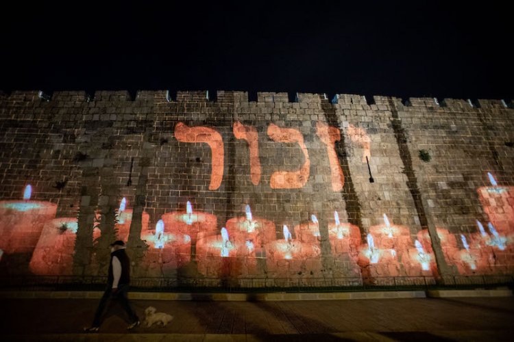 שמותיהם של חיילים ישראלים שנפלו מוקרנים על חומות העיר ירושלים, הערב (צילום: יונתן זינדל, פלאש 90)