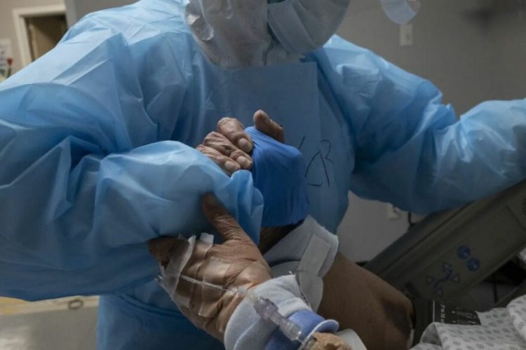 איש צוות רפואי מסייע לחולה קורונה בארה"ב. צילום go nakamu