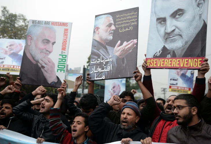 תושבים בעיראק מניפים שלטים של קאסם סולימאני (קרדיט: shutterstock)