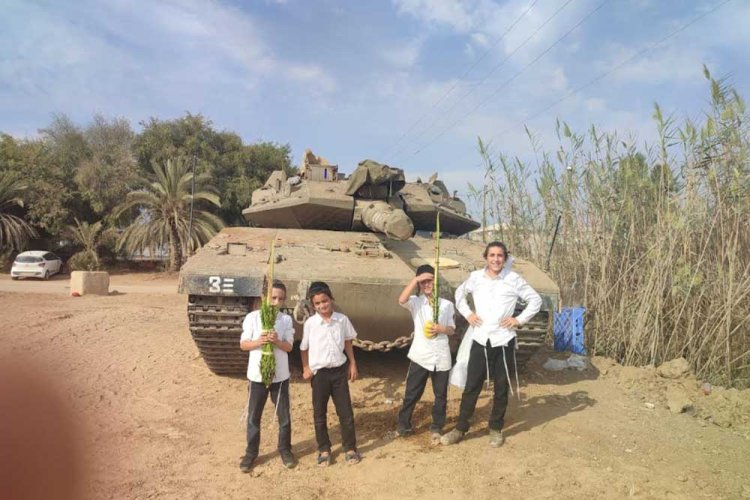 ילדיו של לוי בסוכות שקדם לטבח, עוברים בין חיילי צה''ל בעוטף