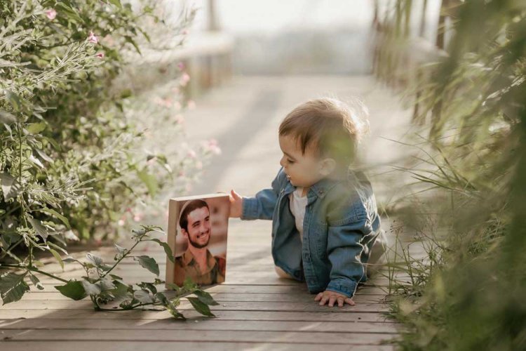 Roy with a photo of his father. Credit: Rinat Turgeman 