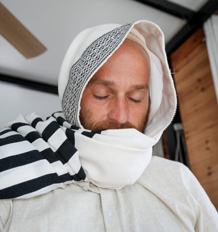 Yosef wrapping himself in a tallit he wove