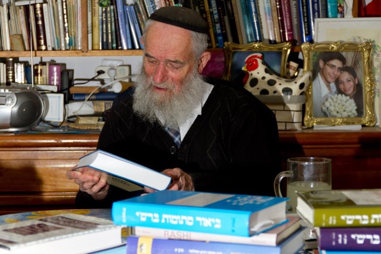 Flipping through books he wrote at home on his desk