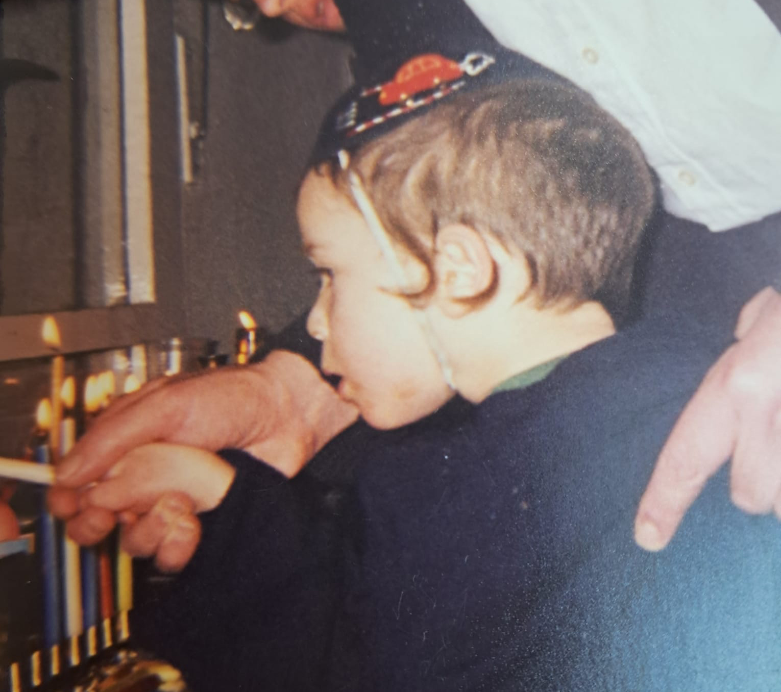 כילד בהדלקת נר חנוכה