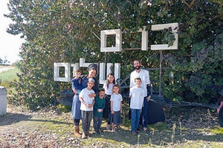 The Schindler family at the entrance of the Kibbutz. 